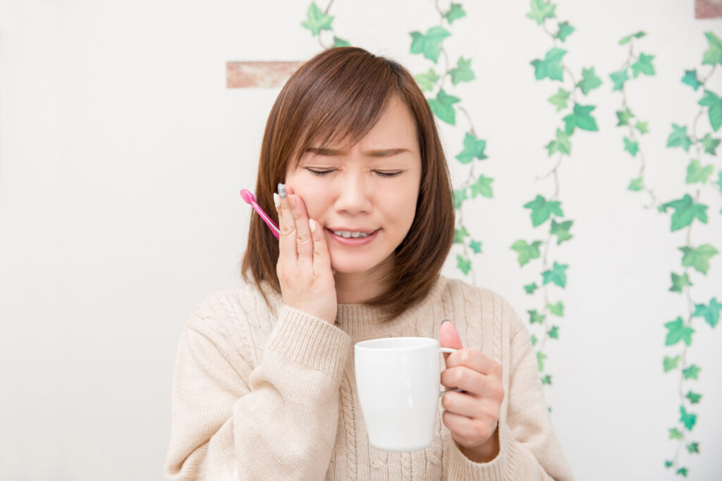知覚過敏で歯がしみる様子の女性