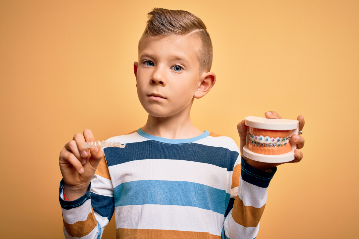 マウスピースと歯の模型をもっている男の子