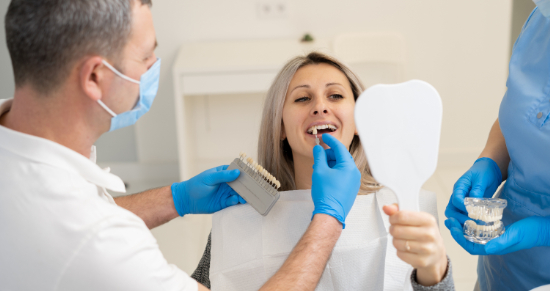 歯科医院でセラミック歯の色を確認する女性患者