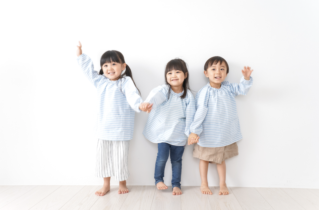 3人の子どもが手を挙げている画像