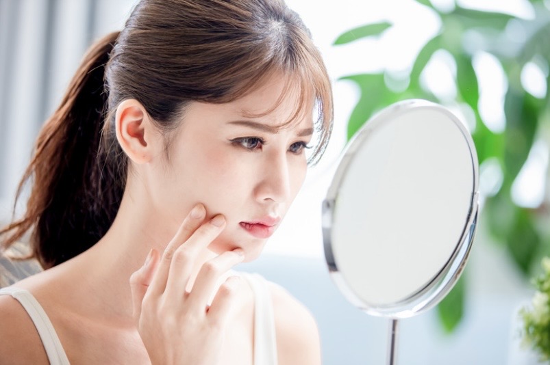 鏡を見て悩む女性